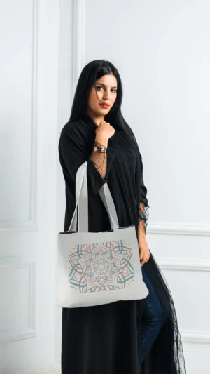 امرأة سعودية ترتدي عباءة سوداء وحقيبة كتف عريضه بيضاء